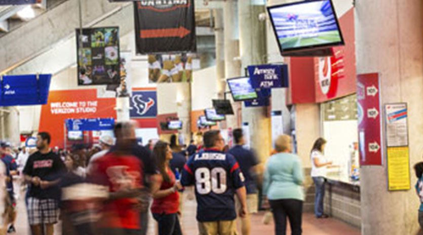 Stadium lobby area full of fans and video displays